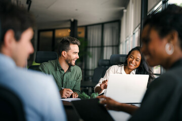 Group of young multi-ethnic startup business team collaborating on project in modern office