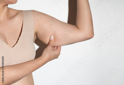 Woman pinching arm fat for body check
