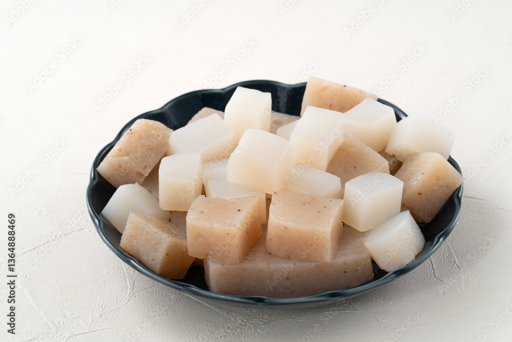 Raw konjac in square shape, also named konnyaku in Japan. Raw konjac in square shape, also named konnyaku in Japan.