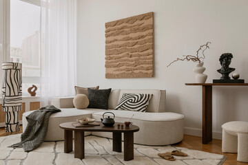Elegant lounge space with curved sofa, abstract artwork, and a curated console arrangement in earthy hues...