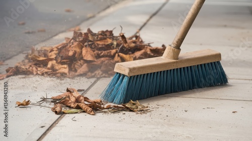 Autumn Cleaning: Sweeping Fallen Leaves on a Pavement