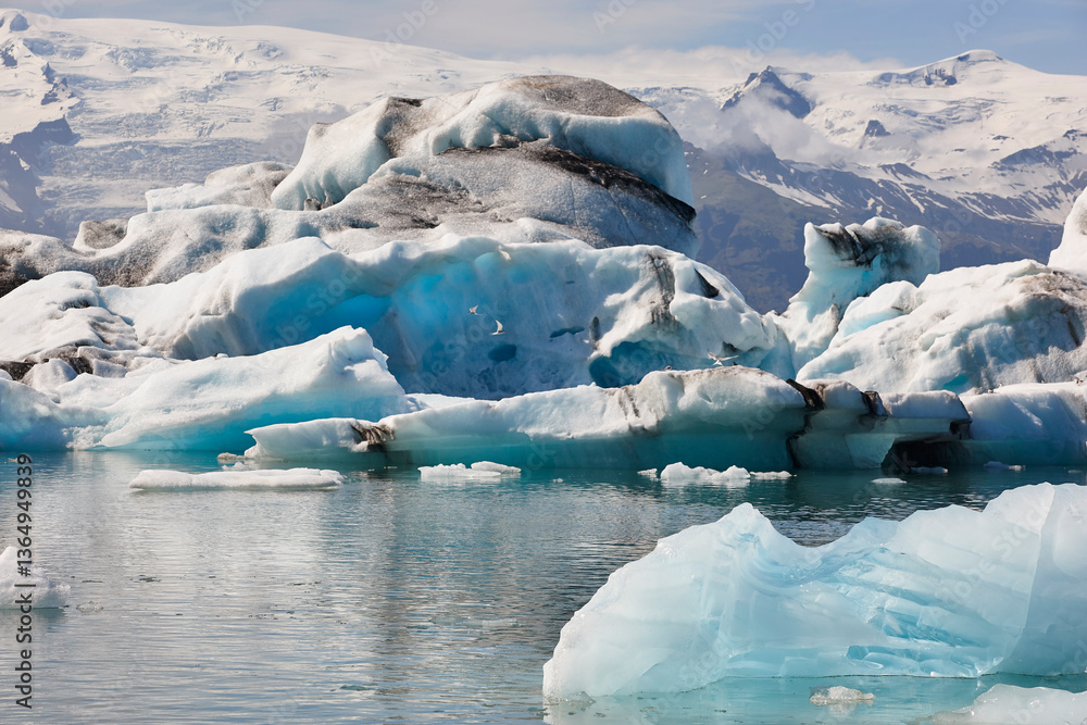 Icebergs turquoise lake and snowy mountains. Jokulsarlon, Southeast area. Iceland.