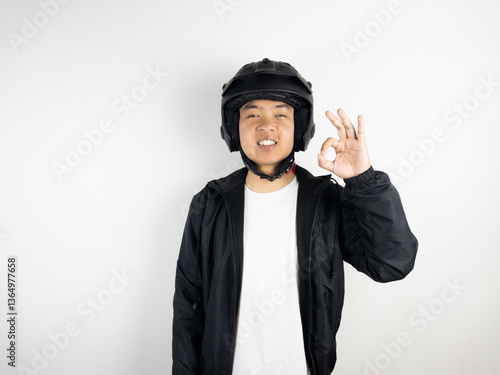 Young Asian man wearing motorbike helmet giving 