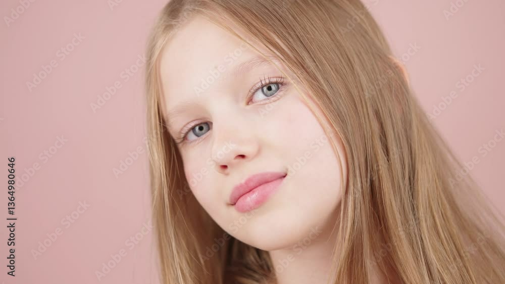 A young Generation Alpha funny girl with flawless fair skin blows a kiss to the camera, posing on a pink studio background. Concept of beauty, skincare, self-care for kids and teenagers. Advertising. A young Generation Alpha funny girl with flawless fair skin blows a kiss to the camera, posing on a pink studio background. Concept of beauty, skincare, self-care for kids and teenagers. Advertising.