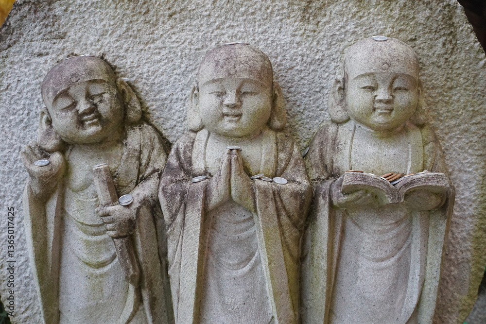 Obraz premium Many stone statues of Jizo are lined up in Japanese temples.