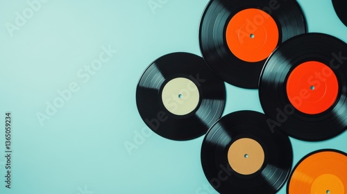 Vintage vinyl records scattered on a soft blue background showcasing retro music culture, nostalgic vibes, and artistic arrangements of classic albums