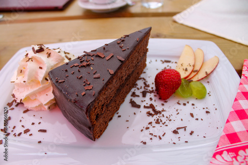 sacher torte in the plate with cream and fruits