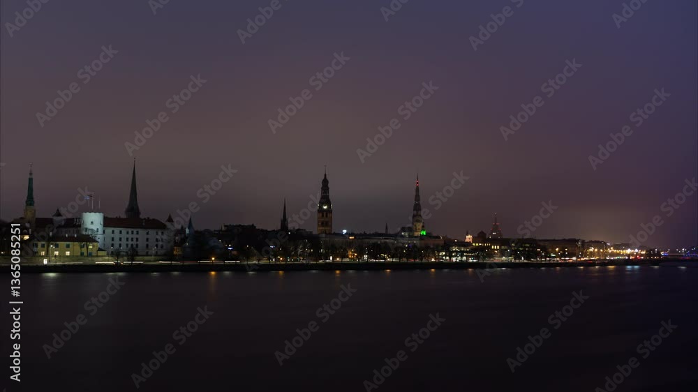 Time lapse. Night panoramic view of the historical center of Riga across the Daugava river. Beautiful embankment lighting and dense night traffic Time lapse. Night panoramic view of the historical center of Riga across the Daugava river. Beautiful embankment lighting and dense night traffic