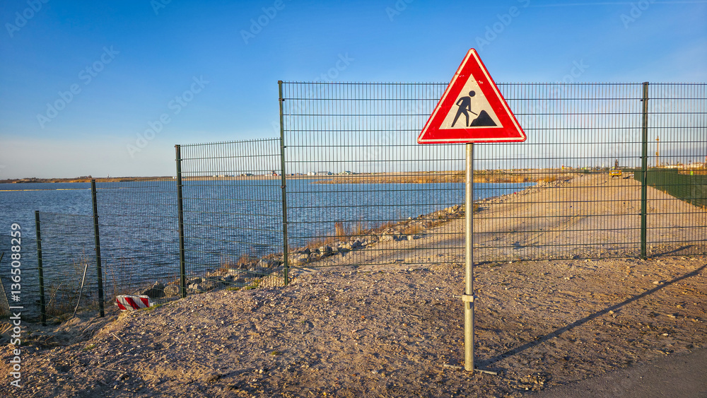 Works in progress warning sign on barren roadside