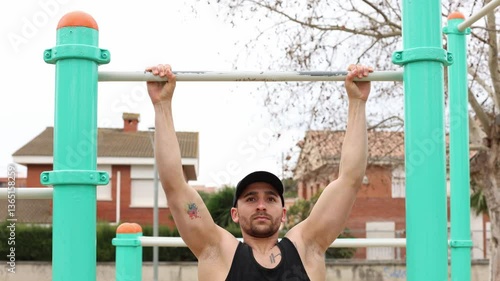 A fit man jogs in a residential area, wearing black athletic clothing and a cap.