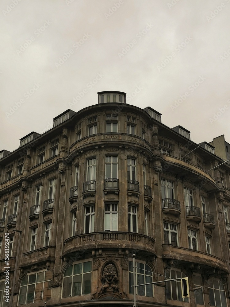 Obraz premium A historic multi-story building with a curved façade and ornate architectural details.