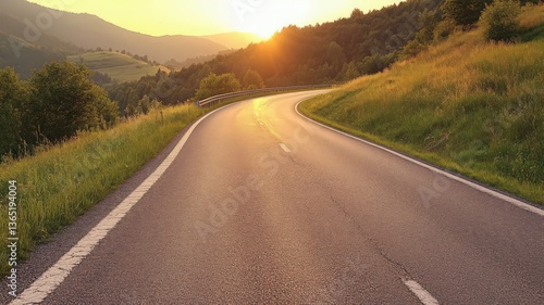 Asphalt Road Winding Through Lush Green Hills at Sunset