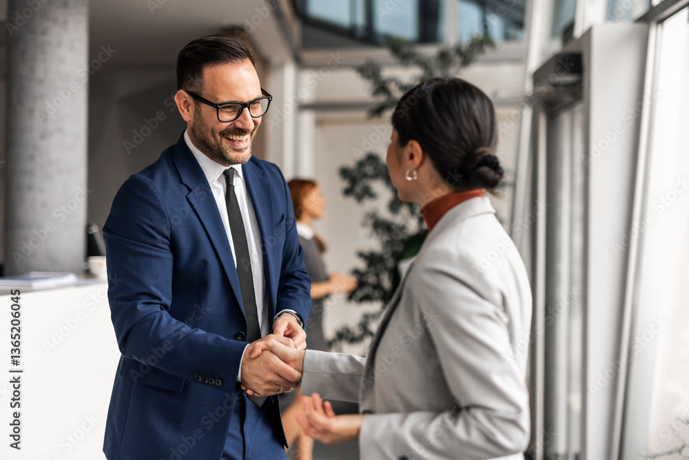 Professional Business Colleagues Shaking Hands in Modern Office Setting Professional Business Colleagues Shaking Hands in Modern Office Setting