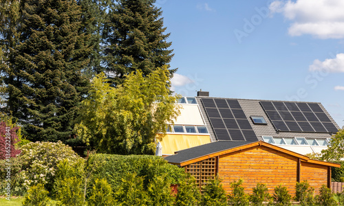 European house near trees with solar panels on the roof
