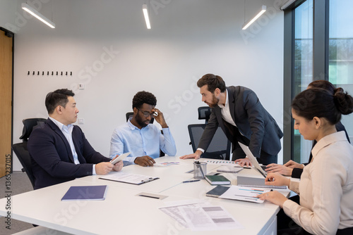 Bilde på lerret An angry businessman berates his team in a modern office boardroom, creating a tense atmosphere during a crucial meeting