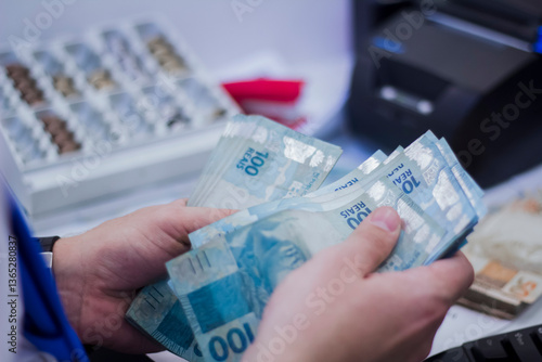 Businessman counting and exchanging money - Brazilian Real - Reais.