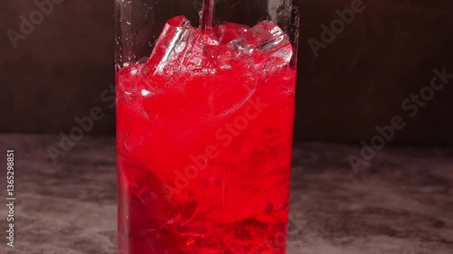 Red soda drink with ice cubes, Close up of soda fizzy drink in Cold glass, macro of red soft drink 