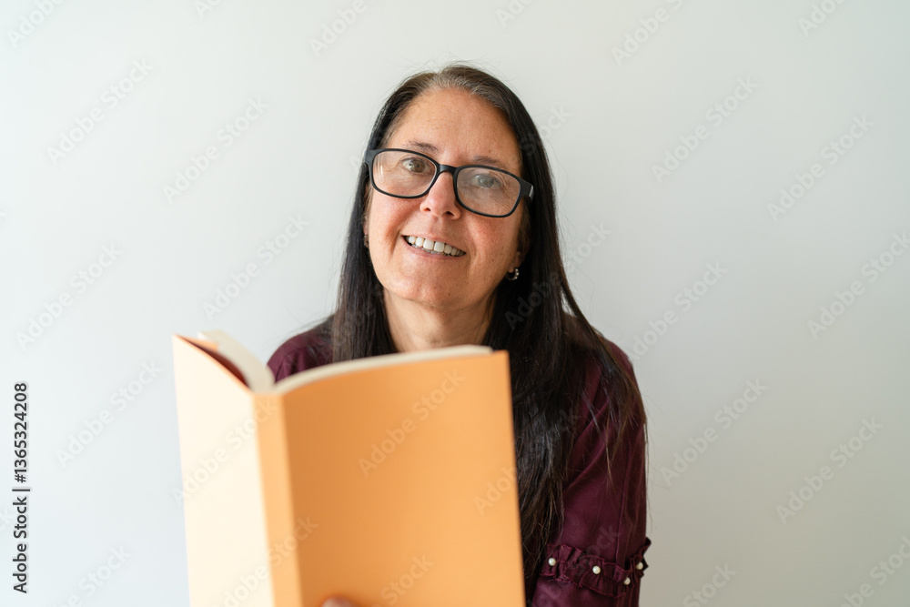 Happy woman reading a book and looking at the camera. Happy woman reading a book and looking at the camera.