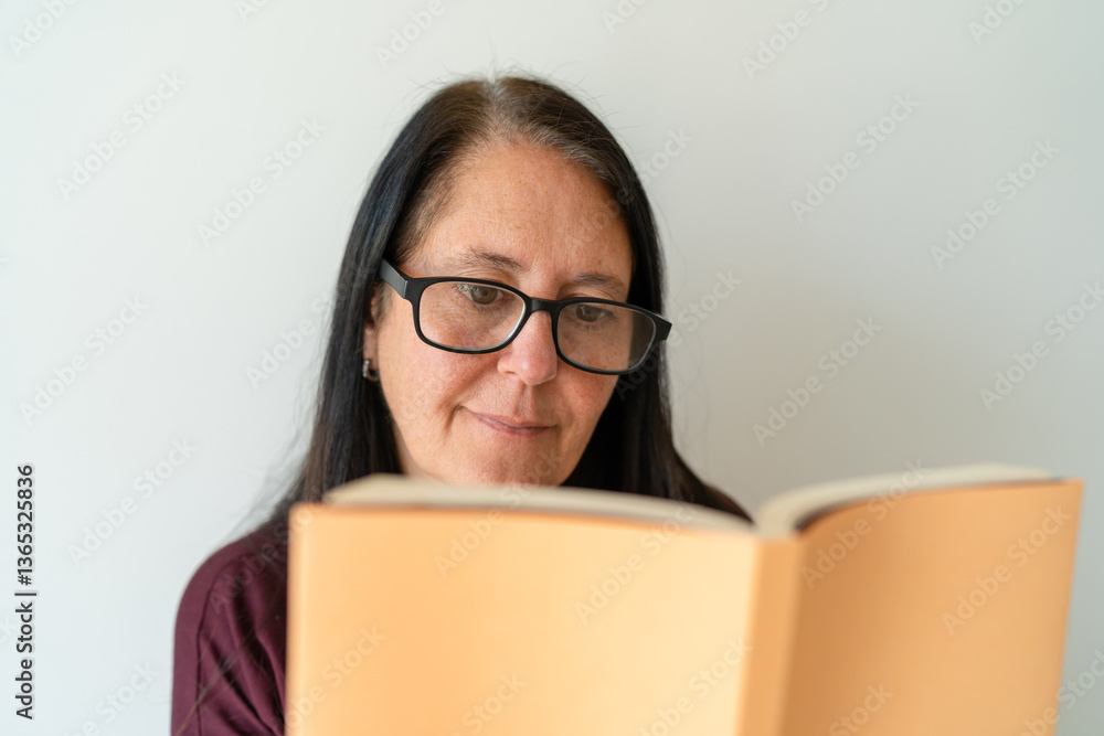 Woman in her 50s enjoying a good book. Concept of reading in your free time. Woman in her 50s enjoying a good book. Concept of reading in your free time.