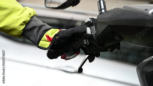 Footage of the biker putting his hand on the handlebar of the motorcycle and pressing the button