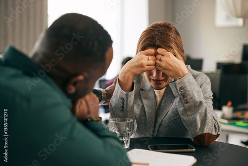 Male business professional consoling crying female colleague in office