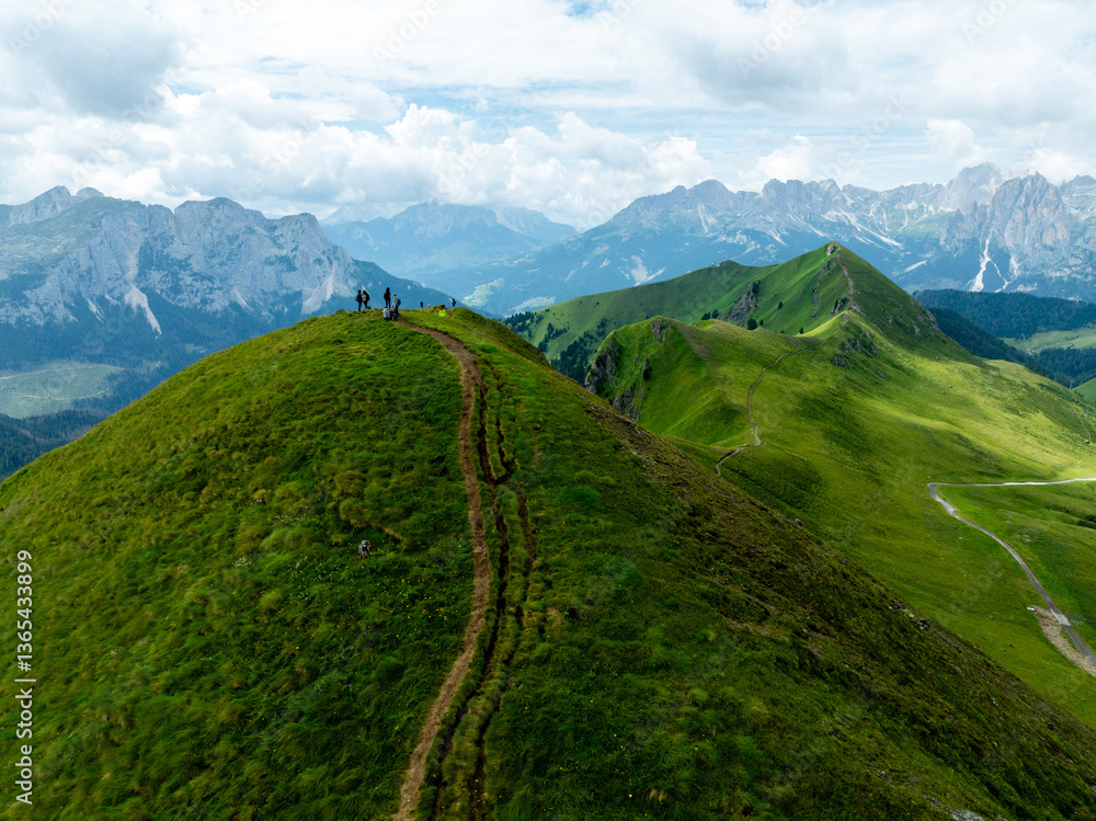 Naklejka premium Aerial Drone View of the Dolomites in Summer, Showcasing Majestic Peaks, Green Valleys, and a Stunning Alpine Landscape Under a Clear Blue Sky with Clouds
