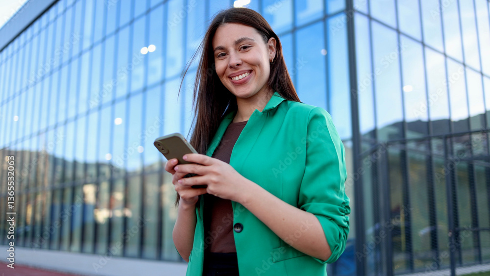 © PeopleVideos - Smiling businesswoman using smartphone in front of modern office building © PeopleVideos - Smiling businesswoman using smartphone in front of modern office building