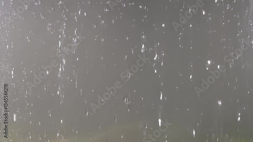Raindrops fall smoothly and glide across the glass surface. 