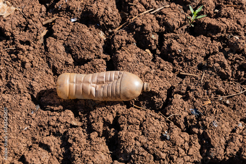 Crack in waterless pond, drying out. Waterless brown land with cracked soil in dry weather
