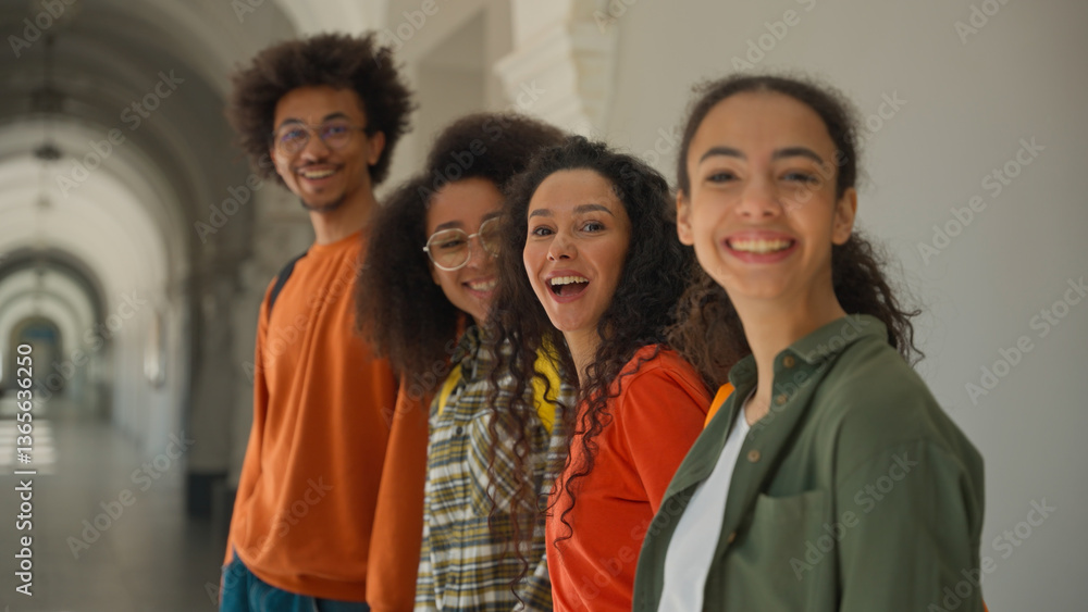 Obraz premium Group happy diversity students in university corridor talking smiling laughing four multiracial friends in college African American man guy with Arabian Hispanic women girls looking to camera positive