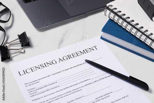 Licensing agreement document, stationery and laptop on white marble table, closeup