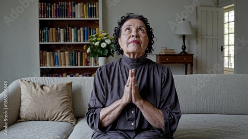 elderly woman praying and looking up, asking for serenity and religious peace at home, flowers and serenity