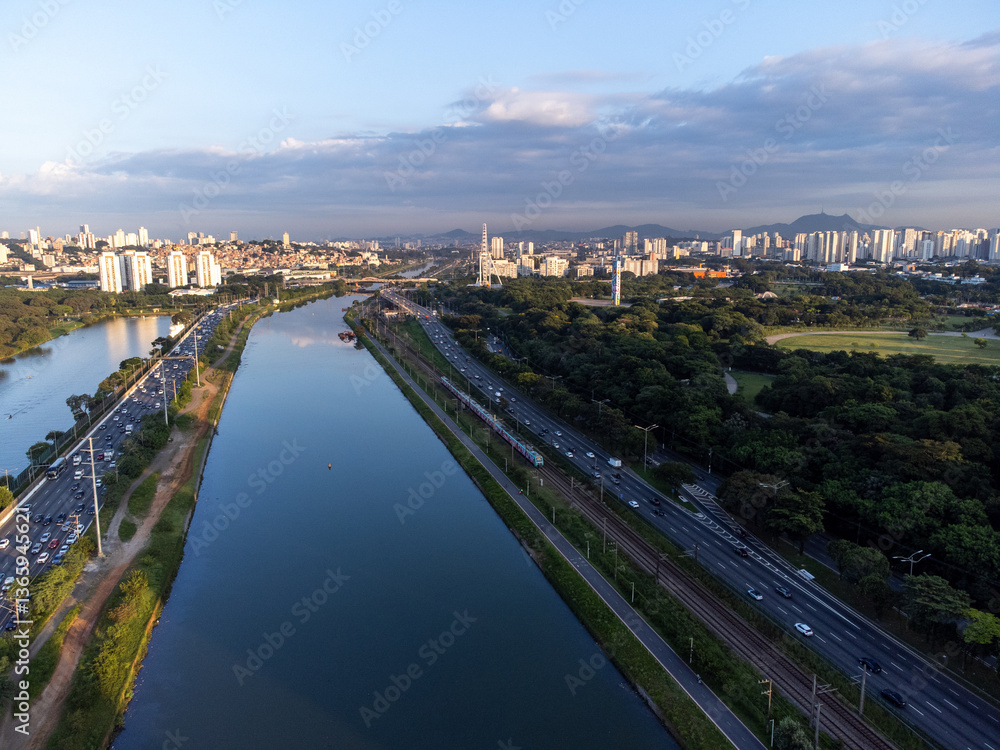 Obraz premium Rising sun on a river within the metropolis of São Paulo with the Pinheiros riverside.