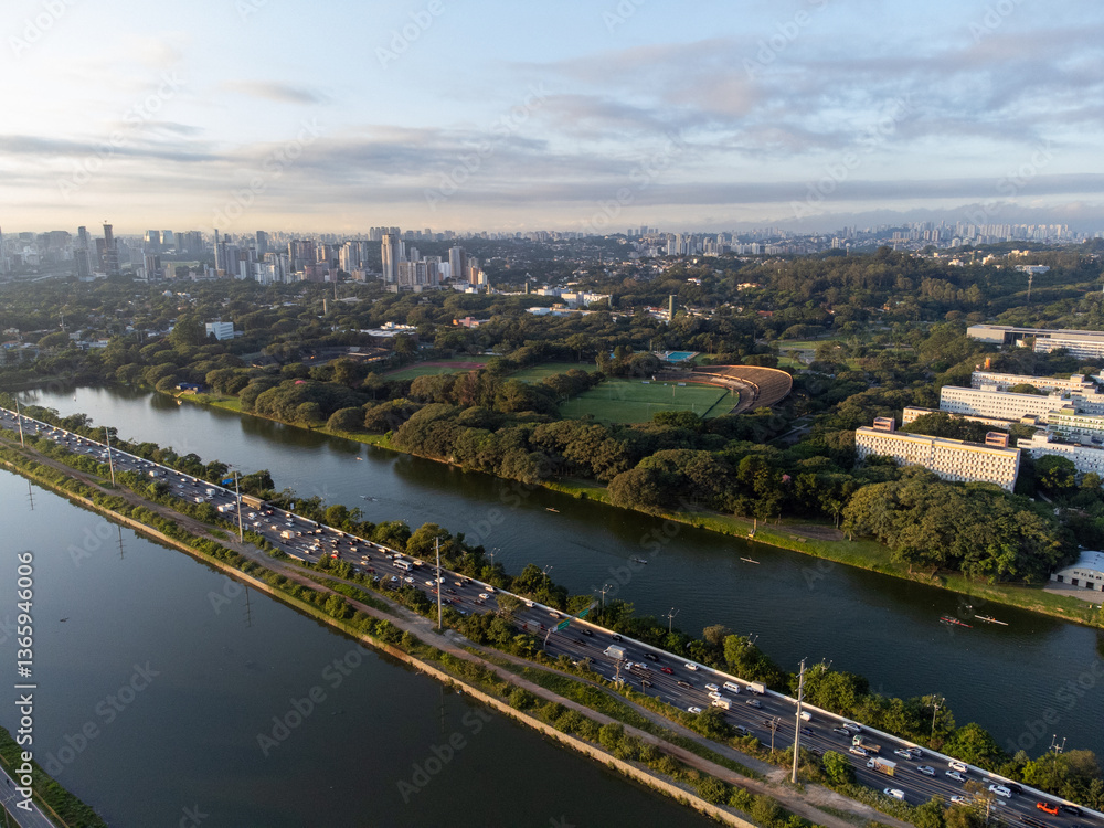 Fototapeta premium Rising sun on a river within the metropolis of São Paulo with the Pinheiros riverside.