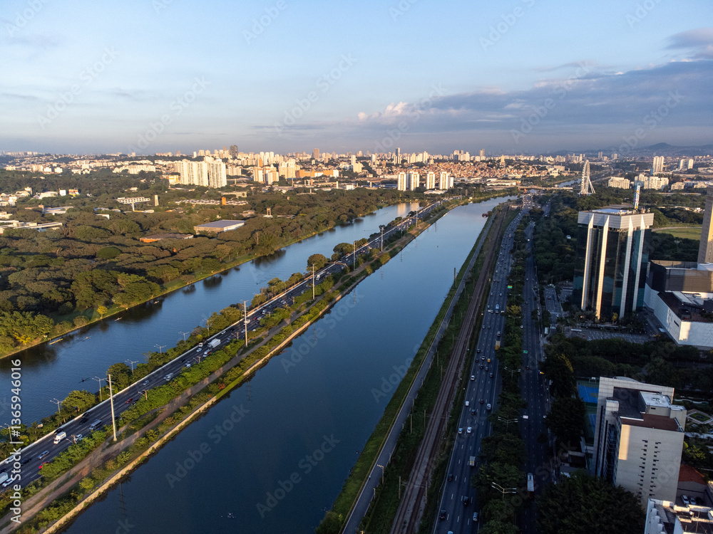 Fototapeta premium Rising sun on a river within the metropolis of São Paulo with the Pinheiros riverside.