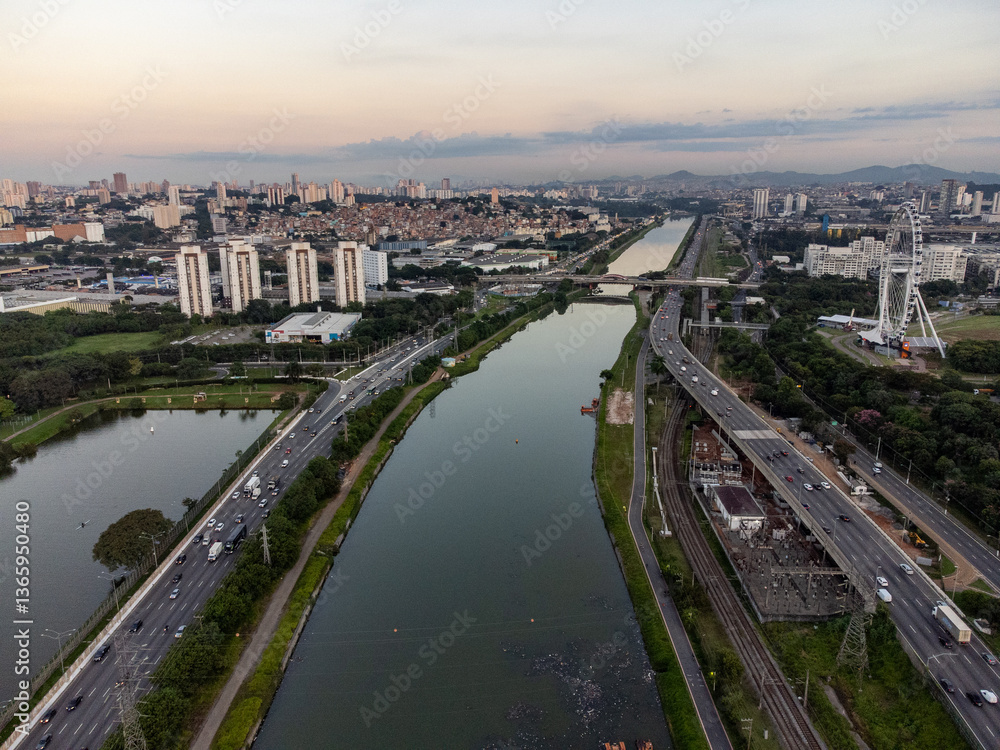 Fototapeta premium Rising sun on a river within the metropolis of São Paulo with the Pinheiros riverside.
