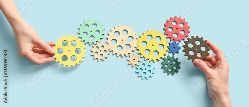 Hands holding wooden gears ...