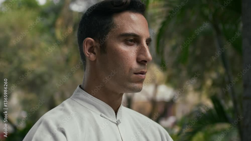 Man practicing Kung Fu with a focused expression, standing outdoors in nature Man practicing Kung Fu with a focused expression, standing outdoors in nature