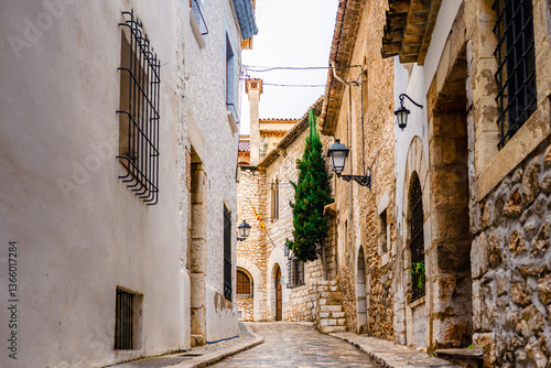 View of the a small street and alleys of Sitges, medieval Spanish town in the coast of Catalonia. Spanish architecture and tourism