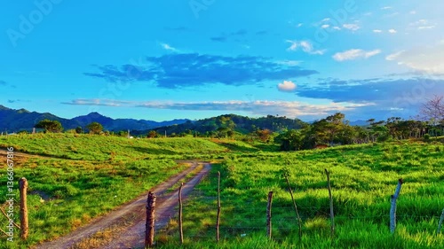 Wallpaper Mural Dominican Republic evening sunset landscape of wild nature. Bird's eye view of endless lush pastures of Caribbean expanses. Green grass and summer blue sky landscape. Rural mountain landscape. Torontodigital.ca