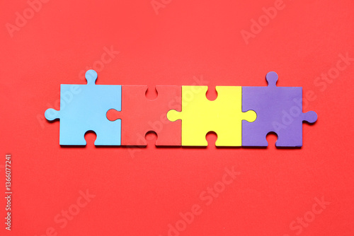 Colorful puzzle pieces on red background. Autistic disorder concept