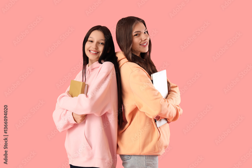 © Pixel-Shot - Happy teenage girls with books and laptop on pink background