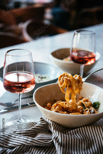 Obraz na płótnie Having a pasta dinner with rose wine at home or in a restaurant. w salonie