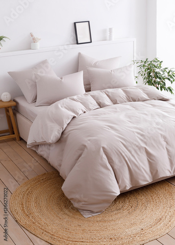 Bedroom with a double bed, fluffy down comforter and four pillows. Top view vertical photo