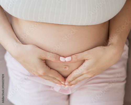 Wallpaper Mural Pregnant woman holds her hands in a heart shape on her belly.  Torontodigital.ca