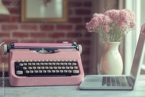 Vintage pink typewriter beside a modern laptop, with pastel flowers in a vase.