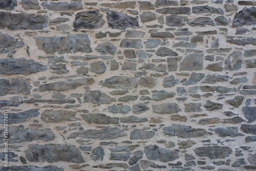 Stone wall made of antique old stone masonry close up. Wallpaper concept