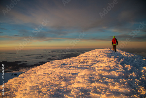 Obraz na płótnie A person on the summit of Mount Rainier above 14,000 feet at sunset in Washington State over the Puget Sound