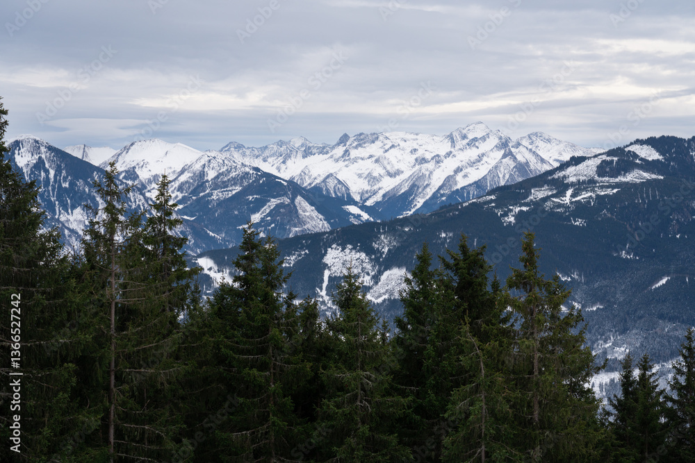 Fototapeta premium Cloudy January alpine landscape with mountains, trees, Austria.