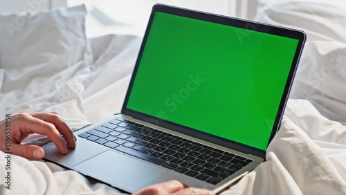 Home manager touching chromakey keyboard laptop in bed closeup. Guy hands typing